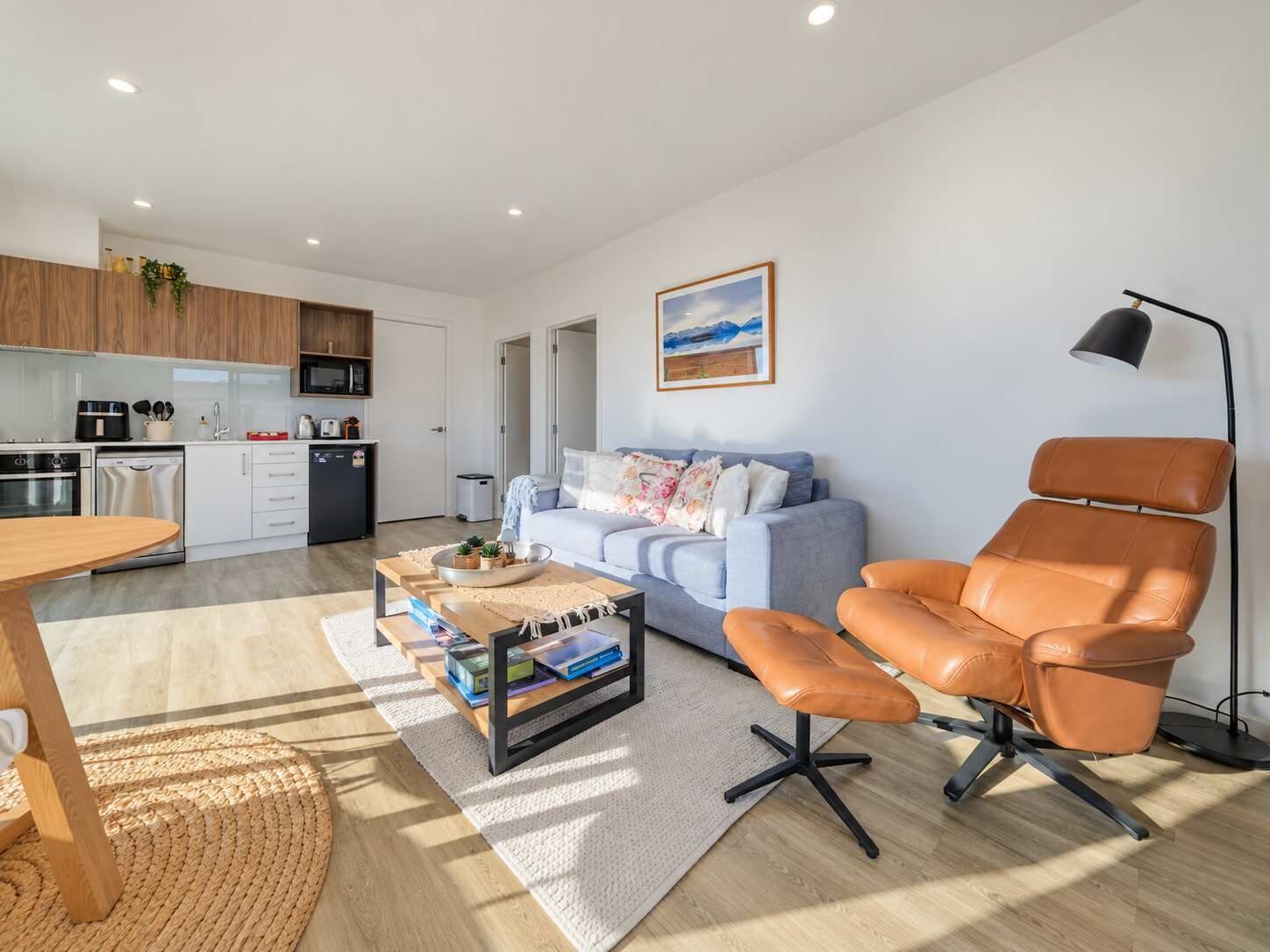 Un salon moderne avec un canapé, une table basse et un fauteuil en cuir.