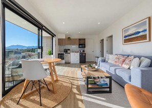 Un espacio habitable moderno con comedor, cocina y sofá.