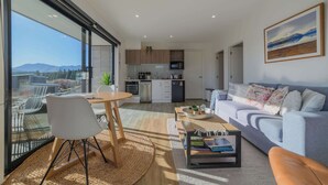 Ett modernt vardagsrum med en soffa, ett soffbord och en matplats.
