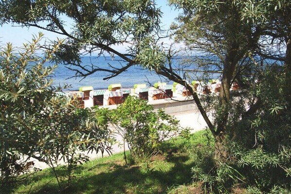 A coastal hotel with outdoor seating, a view of the sea, and a grassy area. - Hohen Niendorf Castle (Hohen Niendorf)