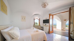 Une chambre d’hôtel équipée d’un lit, d’un bureau, d’une télévision et offrant une vue sur l’extérieur.