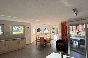 A spacious kitchen with a dining area, large windows, and a view of the outside.