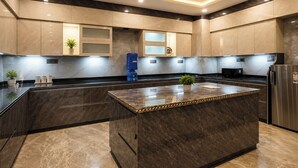 Una cocina moderna con una isla central, electrodomésticos integrados y un ventilador de techo.
