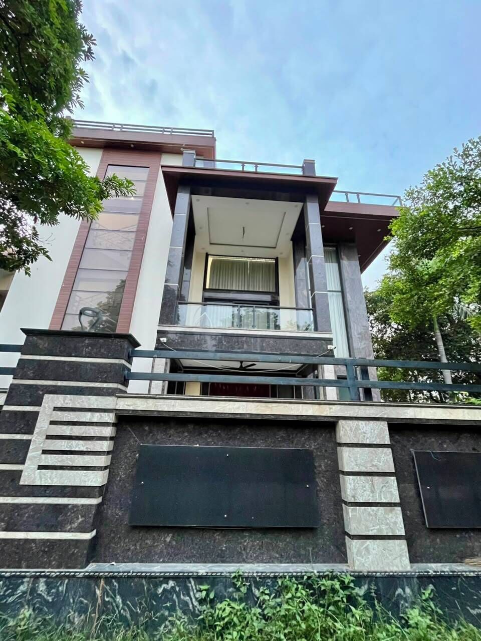 A modern building with a balcony, a staircase, and a large window.