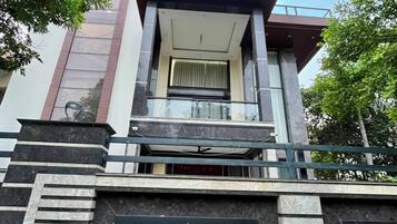 A modern building with a balcony, a staircase, and a large window.
