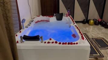 A spa area with a hot tub, a wooden door, and a tiled floor.