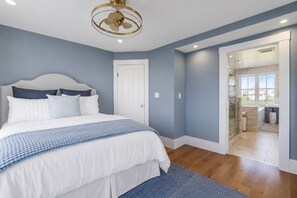 A bedroom with a bed, a door, and a view into a bathroom. - Luxury oceanfront estate, breathtaking ocean views, stunning coastal setting, exceptional amenities, unforgettable getaway. (York)