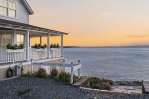 A house with a covered porch overlooking a body of water.