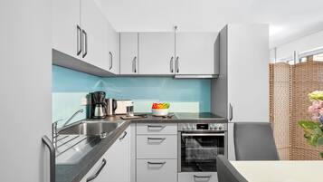 Una cucina moderna con mobili grigi, forno integrato e macchina per il caffè.
