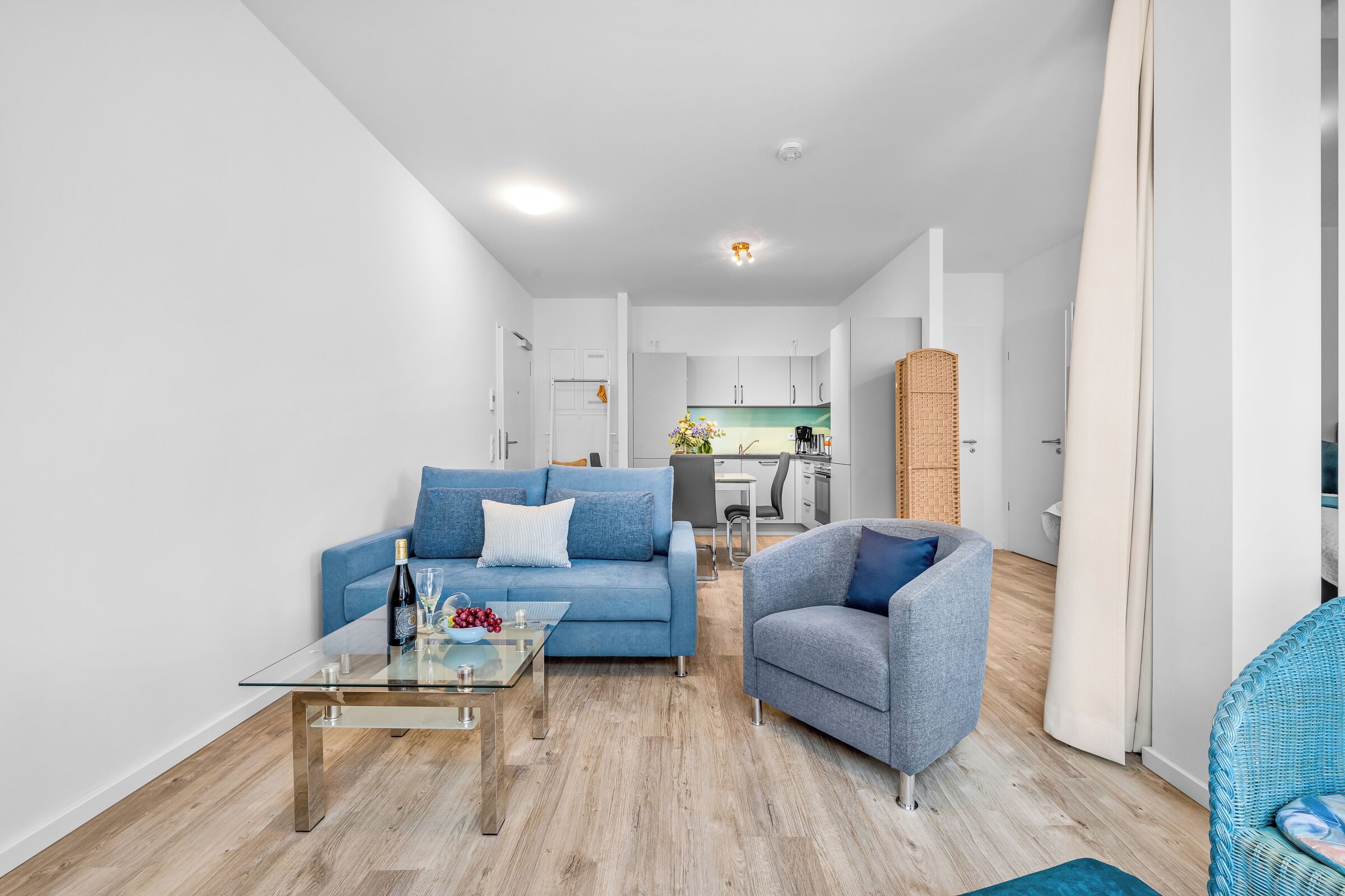 Una sala de estar moderna con sofá, sillón y mesa de centro.
