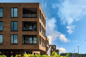 A multi-story building with a brick facade, large windows, and balconies. - Modern Apartment Pure Travemünde with Terrace, Parking and Partial Sea View (Lübeck)