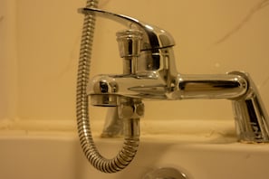 A chrome faucet with a flexible hose, attached to a white sink.