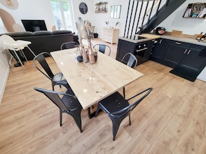 Una cocina moderna con armarios negros, una mesa de comedor de madera y sillas negras.