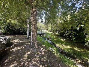 A natural setting with a tree, a small stream, and a bridge in the background. - Studio with parking - 4 guests (Vielle-Aure)