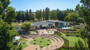 A golf course with a clubhouse, a swimming pool, and a circular driving range.
