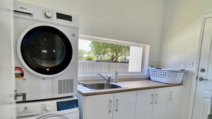 Un cuarto de lavandería con lavadora, secadora y lavabo.