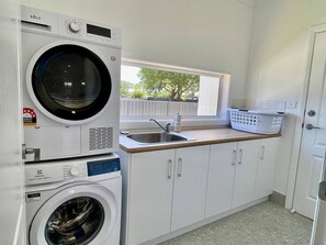 A laundry room with a washing machine, dryer, and sink. - Experience contemporary living in this immaculate 3 bedroom home (Wagga Wagga)