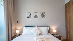 Ein Hotelzimmer mit einem Bett, zwei Nachttischen mit Lampen, einem Kopfteil und drei Wandbildern.