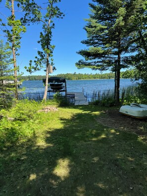 A lakeside dock with a covered seating area, surrounded by trees and vegetation. - Birch Lake-Perfect 4BR cabin on a quiet flat lot with great views in Hackensack (Hackensack)