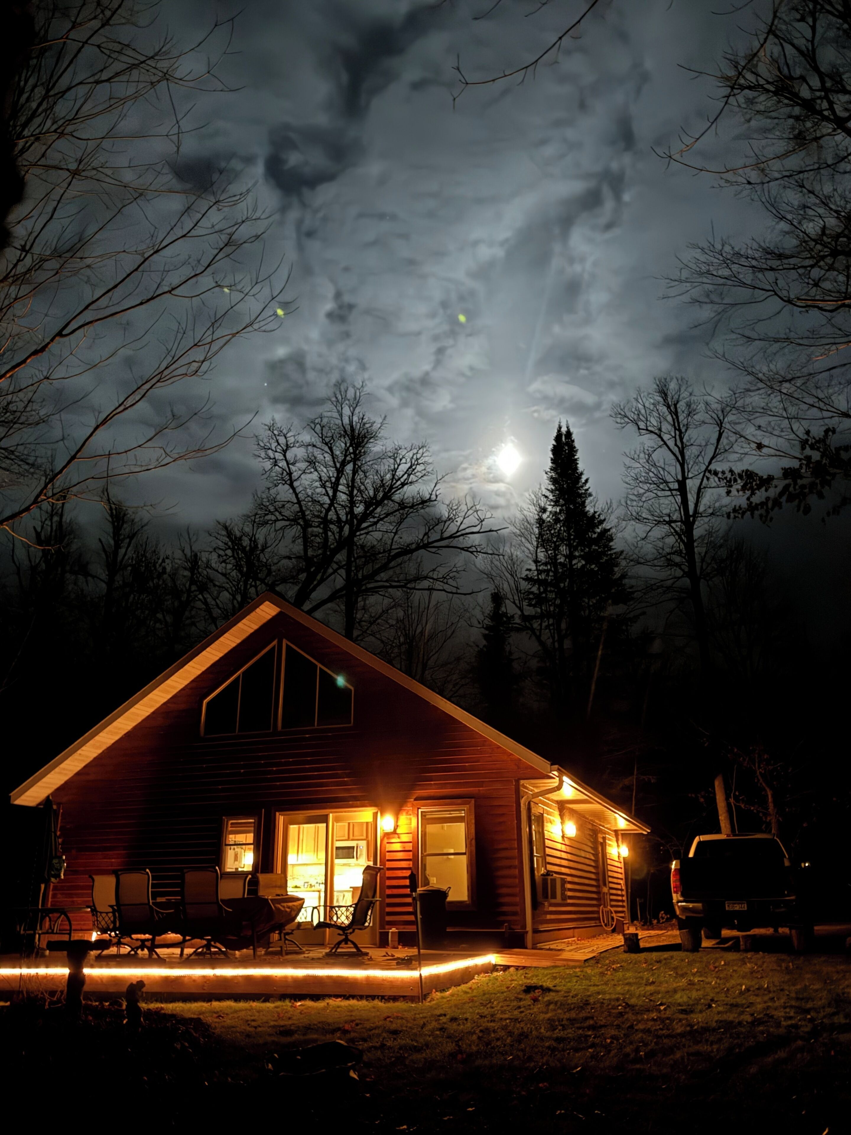 A cabin with a front porch, a dining area, and a garage.
