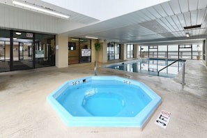 Ein Hallenbad mit einer Tiefenmarkierung von 90 Zentimetern, einem Schild, das die Vorlage eines Pooltickets erfordert, und einem Hinweisschild für den Ausgang.
