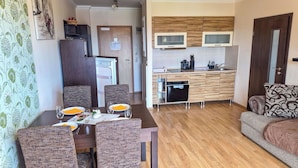 A compact living space with a dining area, kitchenette, and a sofa. - Beautiful apartment for 3 people with WIFI, TV and balcony (Finkenstein Am Faaker See)