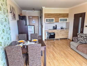 Un espacio habitable compacto con comedor, kitchenette y sofá.