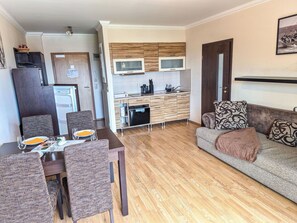 A compact living space with a dining area, kitchenette, and a sofa. - Cosy apartment for 3 people with WIFI, TV and balcony (Finkenstein Am Faaker See)