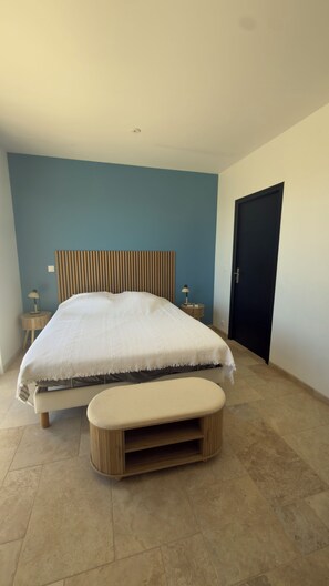 A bedroom with a bed, bedside tables, a bench, and a door. - House with a sea view—perfect for a family vacation—in the town of Seillans (Seillans)