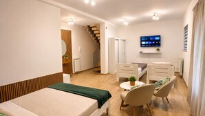 Ein modernes Hotelzimmer mit Bett, Schreibtisch, Stuhl, Fernseher und einer Treppe.