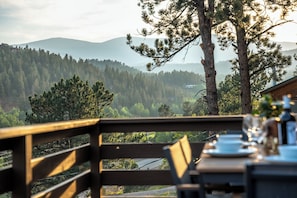 Ein Essbereich mit Blick auf ein bewaldetes Gebirge.