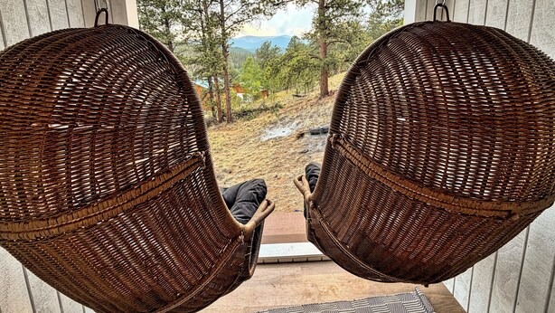 Two wicker swing chairs facing a window with a view of trees and mountains. - Timberline Perch- Hot Tub, Game Room, Bunk Room & Views (Bailey)