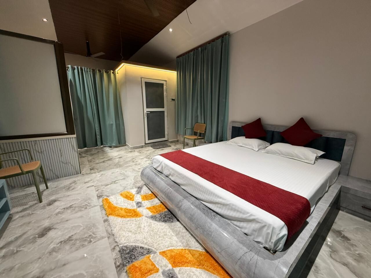 Une chambre à coucher avec un lit, une chaise, un bureau et une porte.