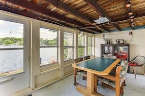 A room with a table and chairs, large windows overlooking a body of water, and a wooden ceiling. - Dock & Sunset Views! Waterfront Thompson Getaway (Thompson)