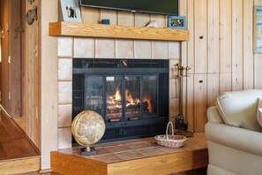 Una chimenea con repisa, un globo terráqueo y una cesta.