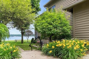 Ein Haus mit Seeblick, umgeben von Grün und gelben Blumen.