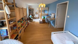 Una stanza con un letto a castello, una scrivania con una sedia, una libreria e una lampada a sospensione.