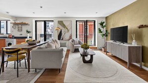 A modern living room with a sofa, coffee table, and TV stand. - Turville Street in London (London)