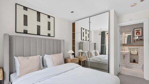 A modern hotel room with a large bed, bedside tables, a mirror, and a wardrobe. - Turville Street in London (London)