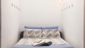 A bedroom with a bed, pillows, and a wall-mounted light fixture. - Just minutes from the city, perfect for everyone—including families with kids (play area) (Bari)