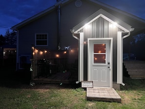 A small wooden structure labeled 'Airbnb Entrance' with a door and a ramp leading up to it. - Charmer Down Under (Kentville)