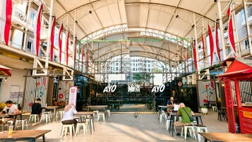 An indoor dining area with tables and chairs, a large glass window, and the name 'AYO' displayed prominently.