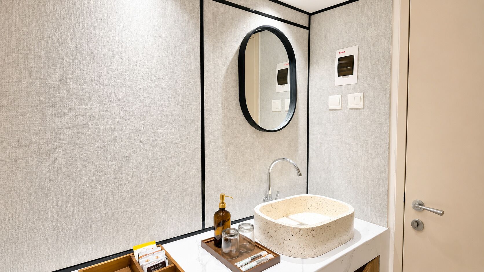 A bathroom with a round sink, a mirror, and a towel rack.