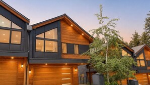 A modern two-story house with large windows, a garage, and a well-maintained garden. - Firework Views from the Private Hot Tub, Luxury Sierra Colina Retreat (SC109) (Stateline)