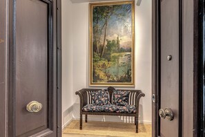 A room with a bench, a painting, and two doors. - BoHo Studio & Terrace (Roma)