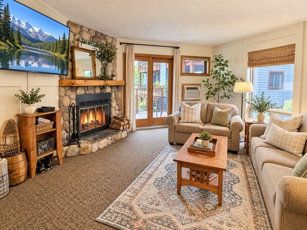 A cozy living room with a fireplace, comfortable seating, and a television.