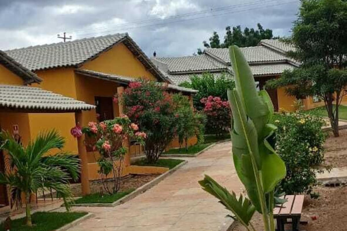 A courtyard with a pathway leading to a building with a tiled roof.