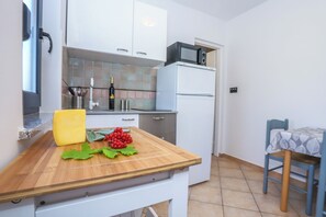A compact kitchen with a wooden countertop, a microwave, and a refrigerator. - Apartment A2 Villa Irena Poreč (Poreč)
