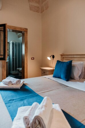 A hotel room with a bed, a nightstand with a lamp, a wooden headboard, and a mirror. - Villa [2 suites] 5 minutes from the sea | air conditioning | garden | BBQ | outdoor shower (Diso)