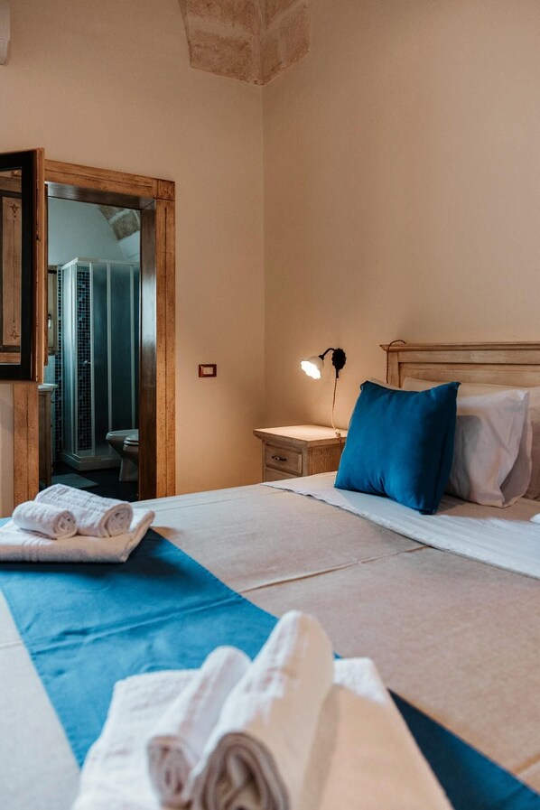 A hotel room with a bed, a nightstand with a lamp, a wooden headboard, and a mirror. - Villa [2 suites] 5 minutes from the sea | air conditioning | garden | BBQ | outdoor shower (Diso)